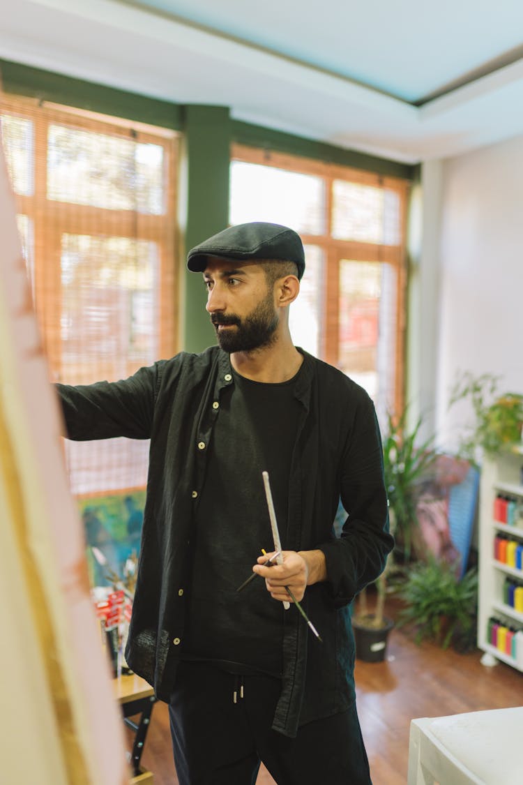 Man In Black Clothes Standing And Painting