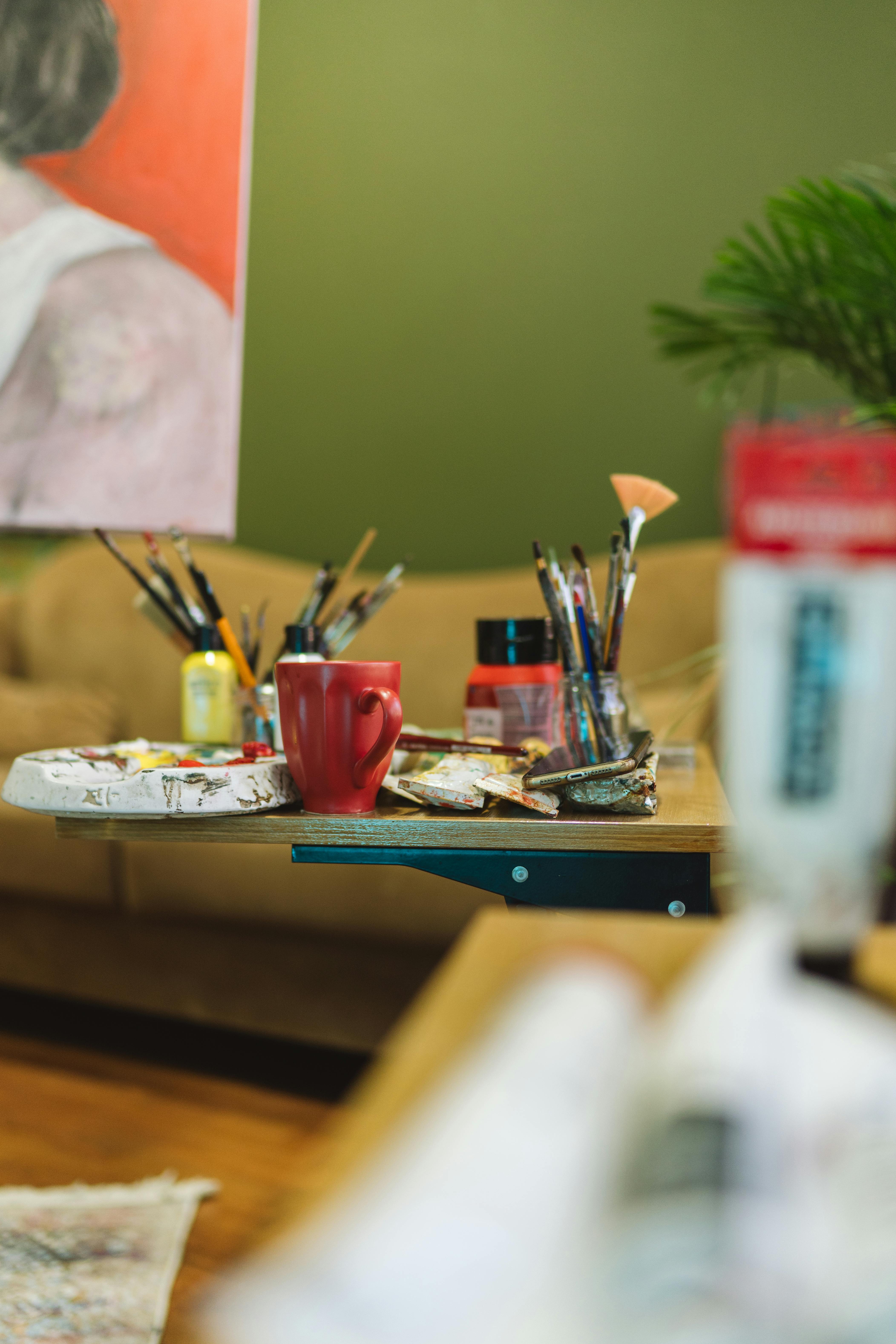 Creative setup featuring art supplies, brushes, and a canvas in a cozy studio.