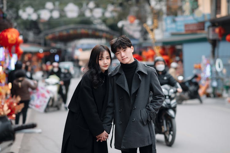 A Young Couple Standing On The Street 