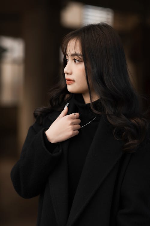 Young woman in a Black Coat Looking Away 