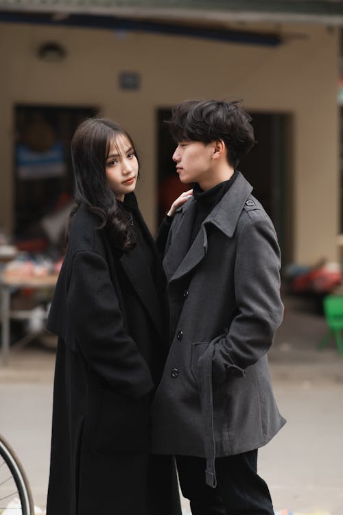 Young Woman and Man Posing in Elegant Coats