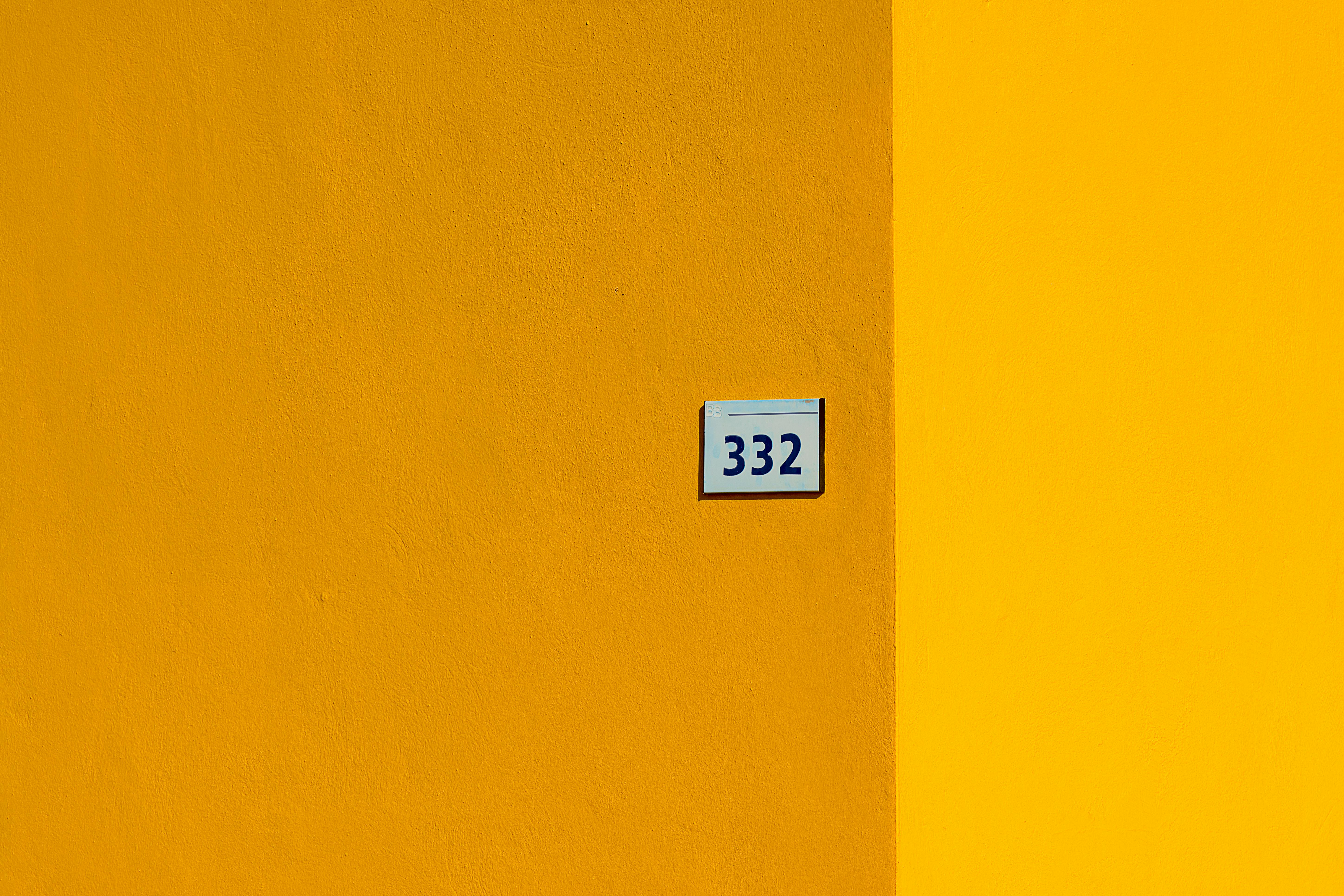 Free Minimalist yellow wall with number 332, showcasing vibrant color contrast. Stock Photo