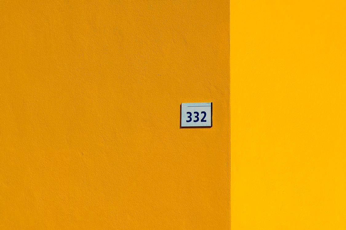 Projecting Yellow Number Sign Yellow Wall with Number Sign · Free Stock Photo