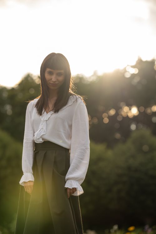 Free Young woman in a sunlit park, surrounded by lush greenery during a summer day. Stock Photo