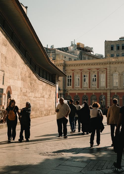 Free People walking in a historic street of Istanbul, Türkiye, with sunlight casting long shadows. Stock Photo