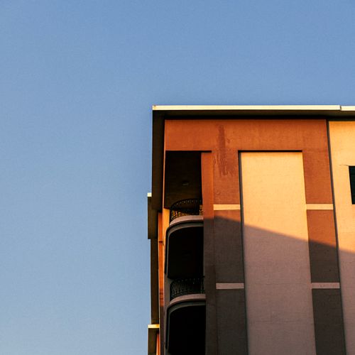 Free Corner view of a modern building in Dubai against a clear blue sky. Stock Photo