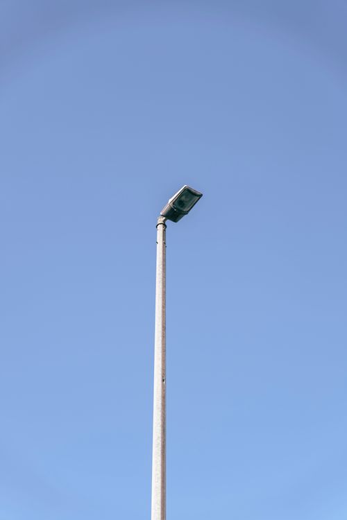Free A solitary street lamp stands tall against a bright blue sky in Dubai, United Arab Emirates. Stock Photo