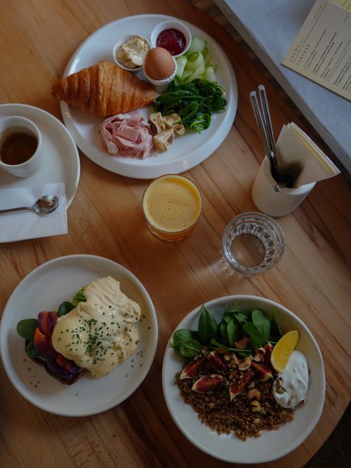 Free A delectable breakfast spread with croissants, eggs, and orange juice on a wooden table. Stock Photo