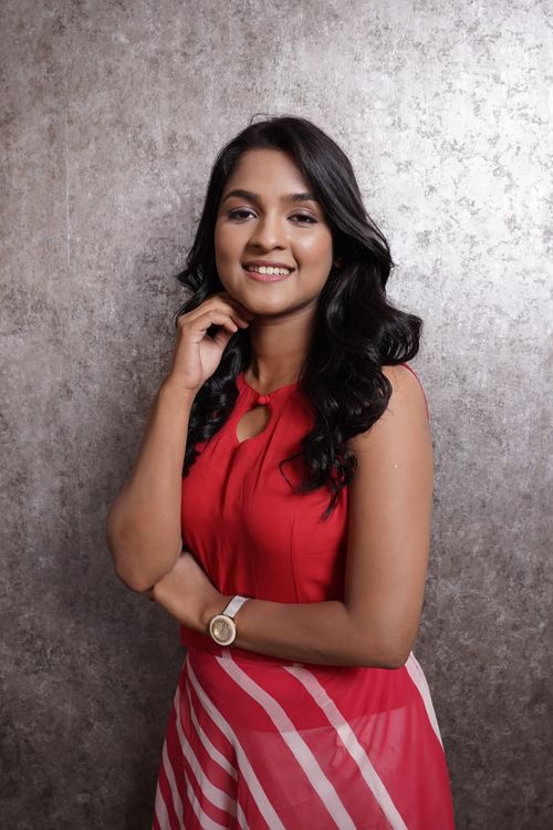 Free Elegant studio portrait of a smiling woman in a striking red dress, exuding confidence and charm. Stock Photo