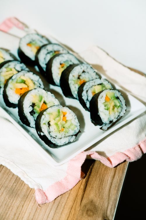 Free Appetizing vegetarian sushi rolls on a white plate, perfect for lunch or dinner. Stock Photo