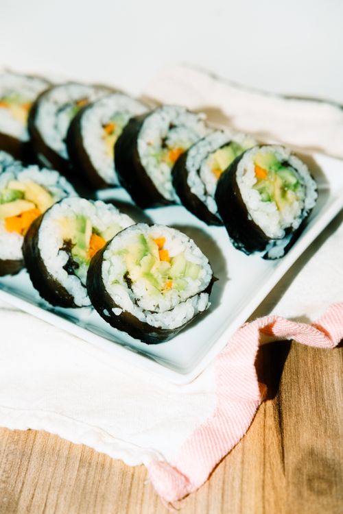 Free Close-up of vibrant vegetable sushi rolls on a white plate, perfect for food photography enthusiasts. Stock Photo