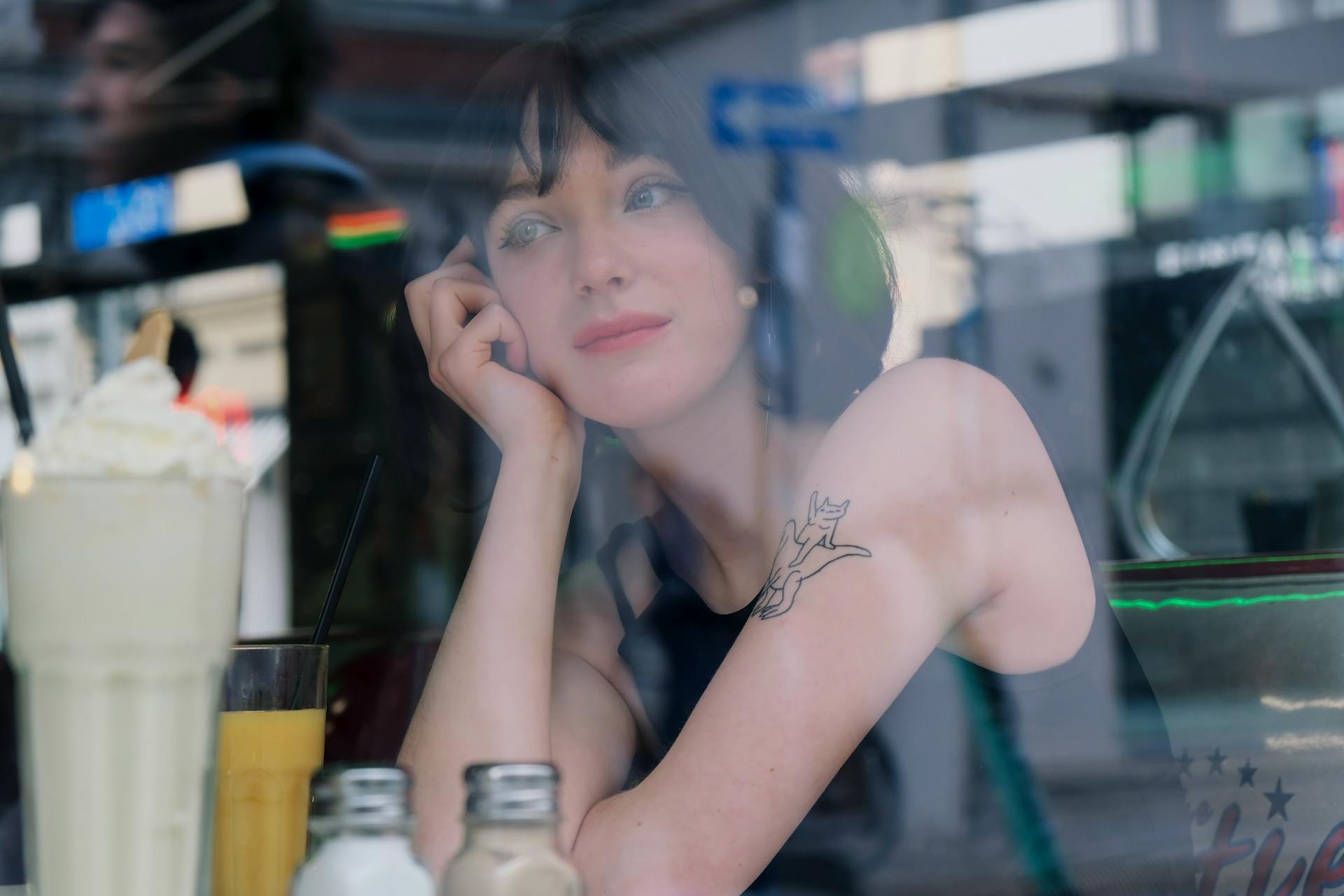 Woman Sitting by Diner Table seen through Glass