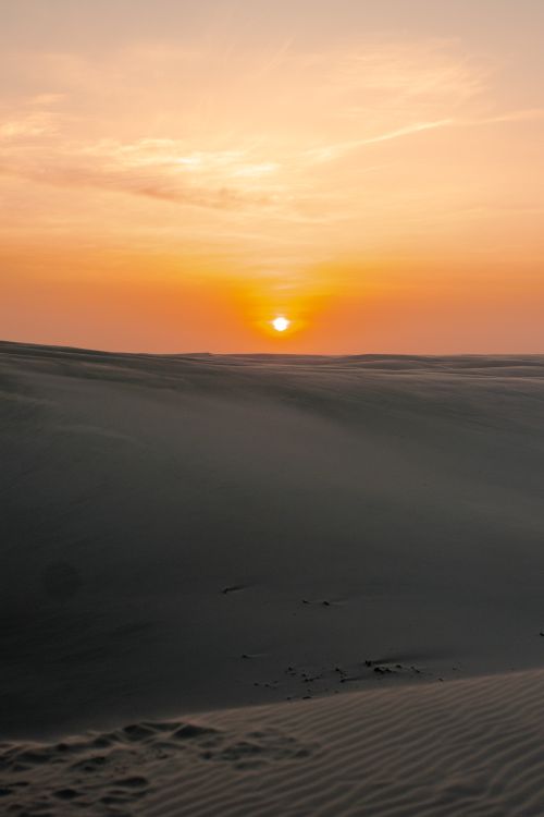 Free A serene sunset casts warm hues over desert dunes in Barreirinhas, Brazil. Stock Photo