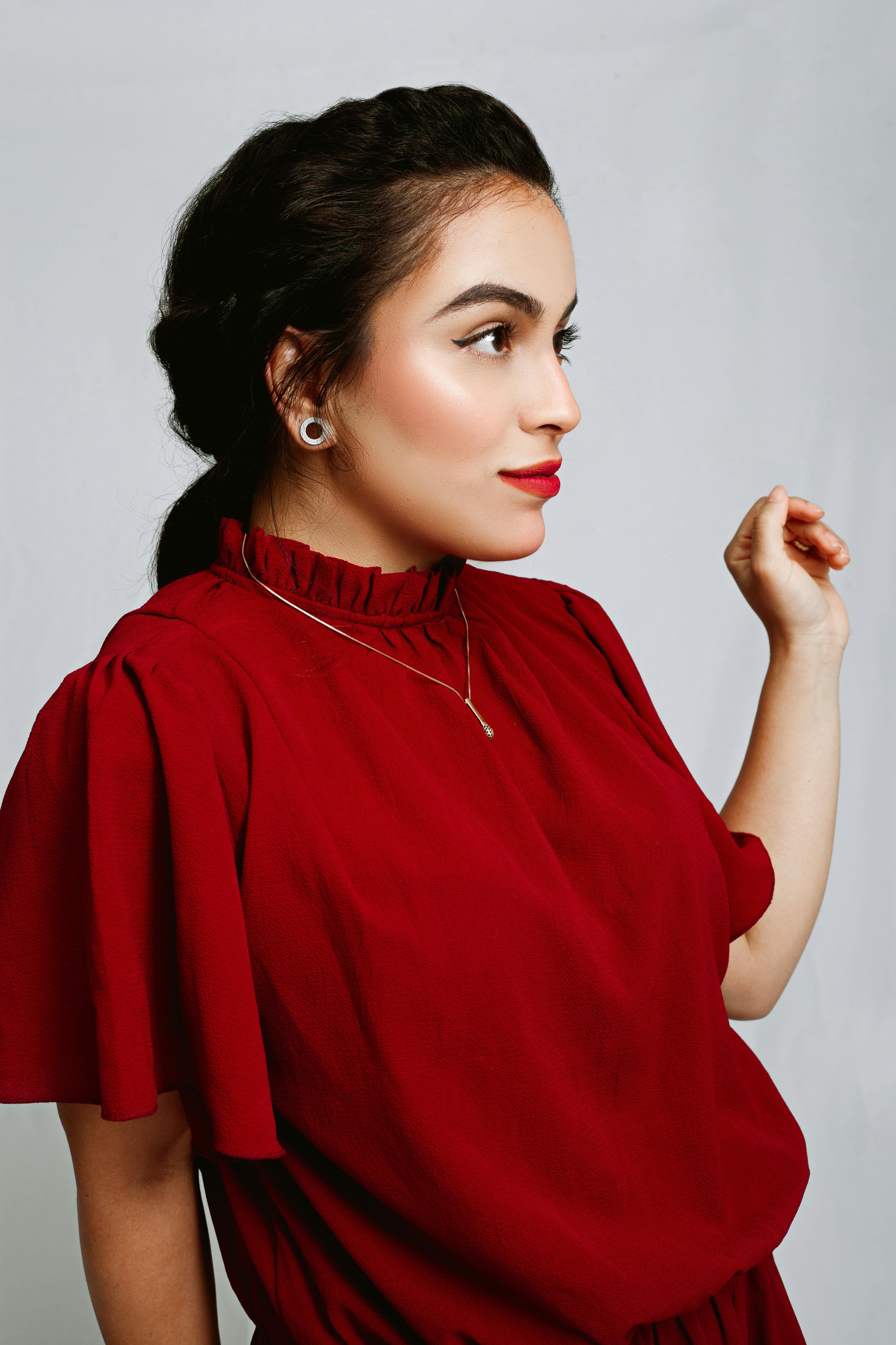 Captivating portrait featuring a woman in red against a gray background, perfect for fashion and beauty themes.