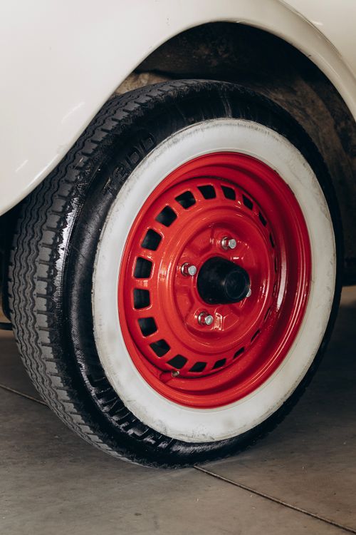 Free Close-up of a vintage car's red wheel with white sidewall tire showcasing retro design. Stock Photo