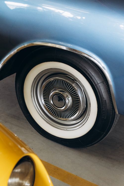 Free Close-up of a vintage car wheel and whitewall tire showcasing retro design. Stock Photo