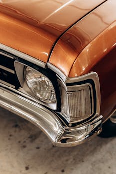 Detailed view of the headlight and bumper of a classic vintage car.