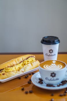 一杯带有艺术气息的拿铁咖啡，配上一份早餐三明治，这迷人的组合非常适合开启一个舒适的早晨