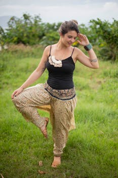 一名女子在户外绿意盎然的景观中练习瑜伽，散发着放松与欢乐的气息