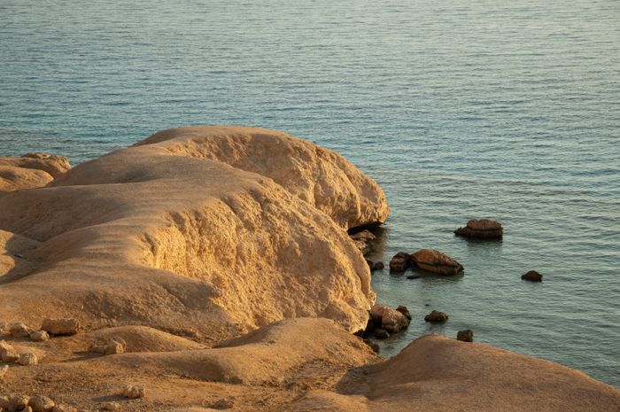 Sunlit rock shelves worn back by the sea — photo by Vika Glitter on Pexels