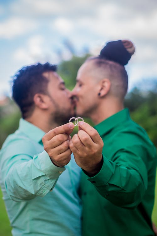 Two Men In Green And Teal Dress Shirts Kissing