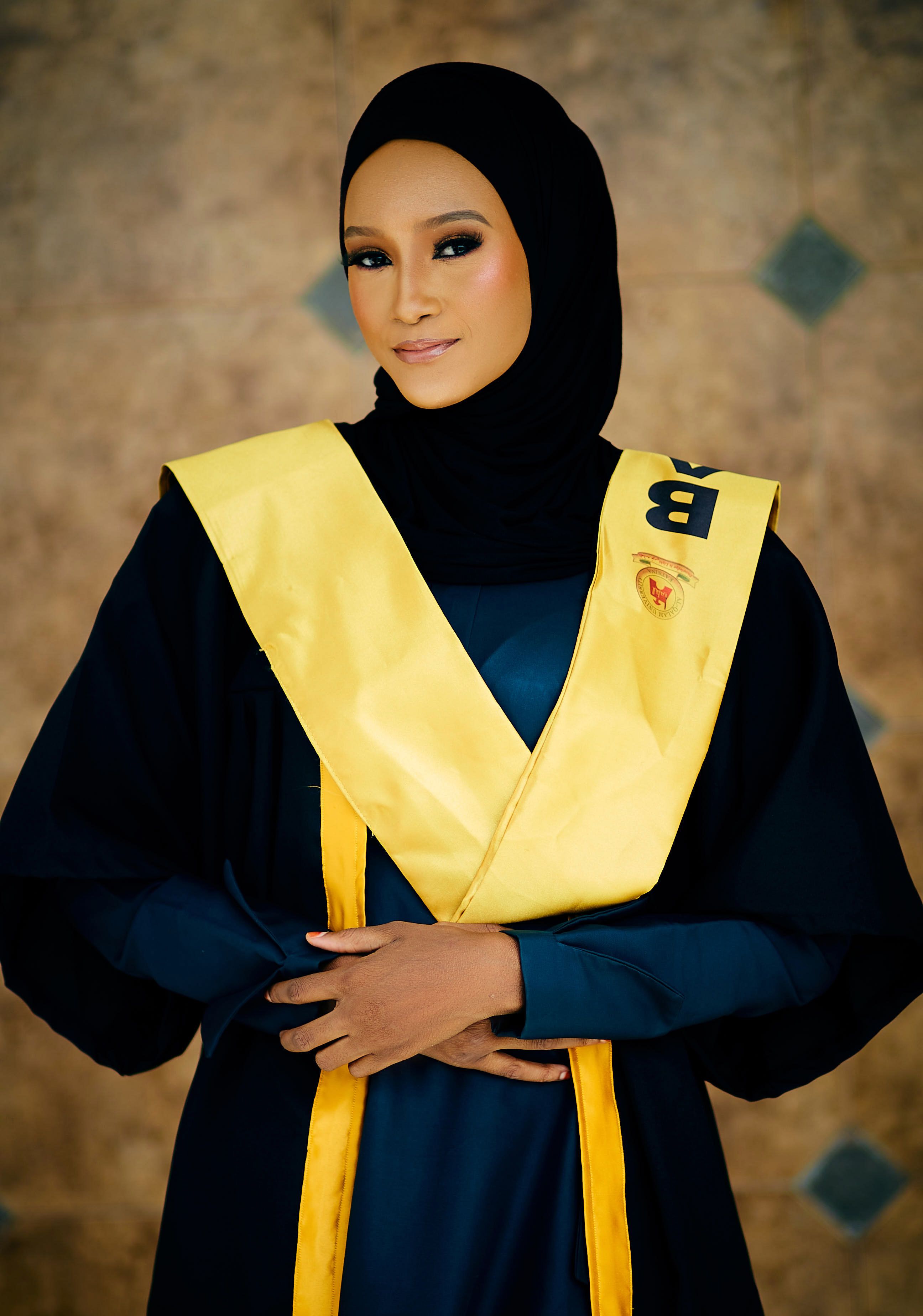 Elegant portrait of a woman in a graduation gown and hijab symbolizing educational success.