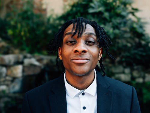 A man with dreadlocks in a suit and tie