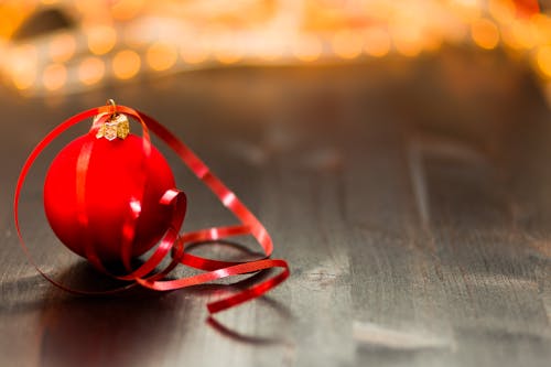 Free Red Christmas Bauble With Red Ribbon on Wooden Surface in Close Up Photography Stock Photo