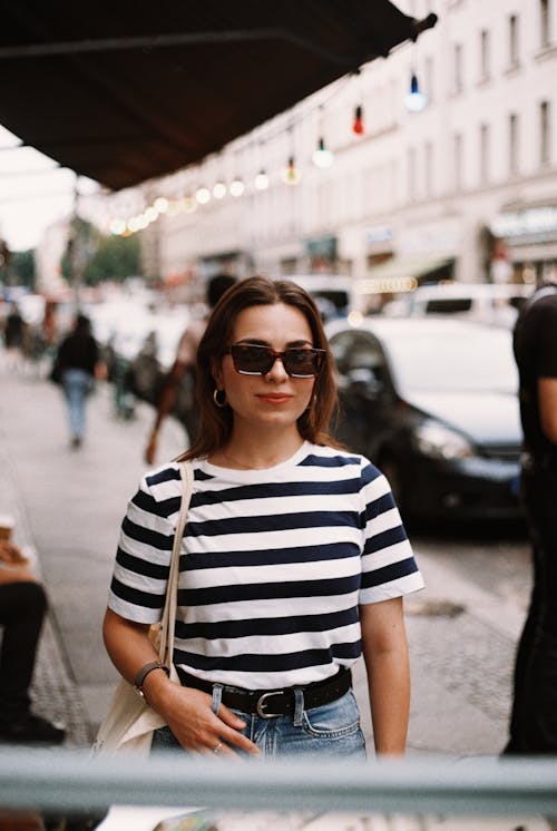Brunette Woman with Sunglasses in Striped T-Shirt on Sidewalk