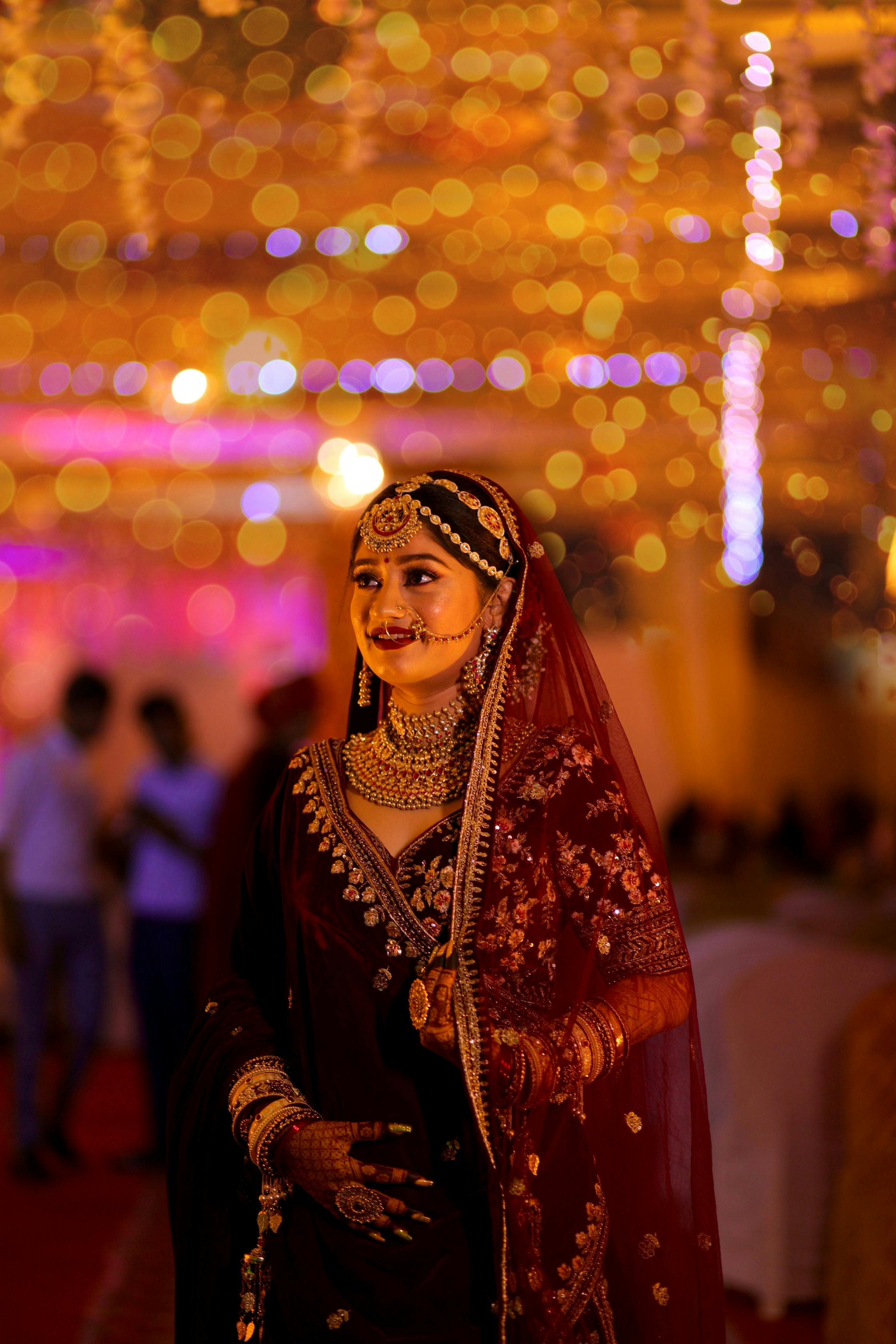 A beautifully dressed Indian bride shines in vibrant traditional attire with intricate jewelry and henna.