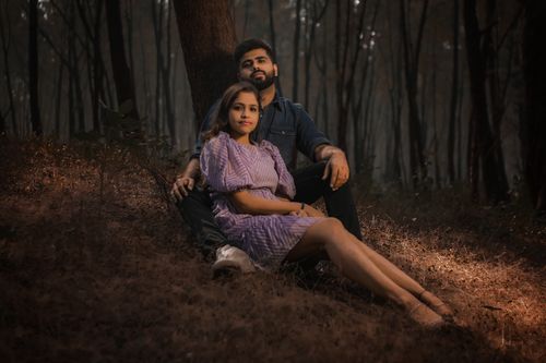 Free A couple enjoying a serene moment in an autumn forest, surrounded by trees. Stock Photo