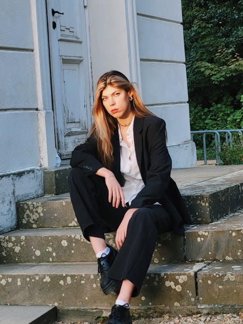 Blonde Woman in Suit Sitting on Stairs