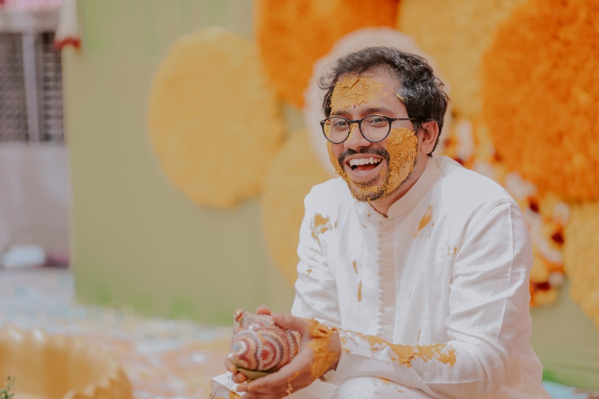 Haldi film still — groom laughing covered in turmeric