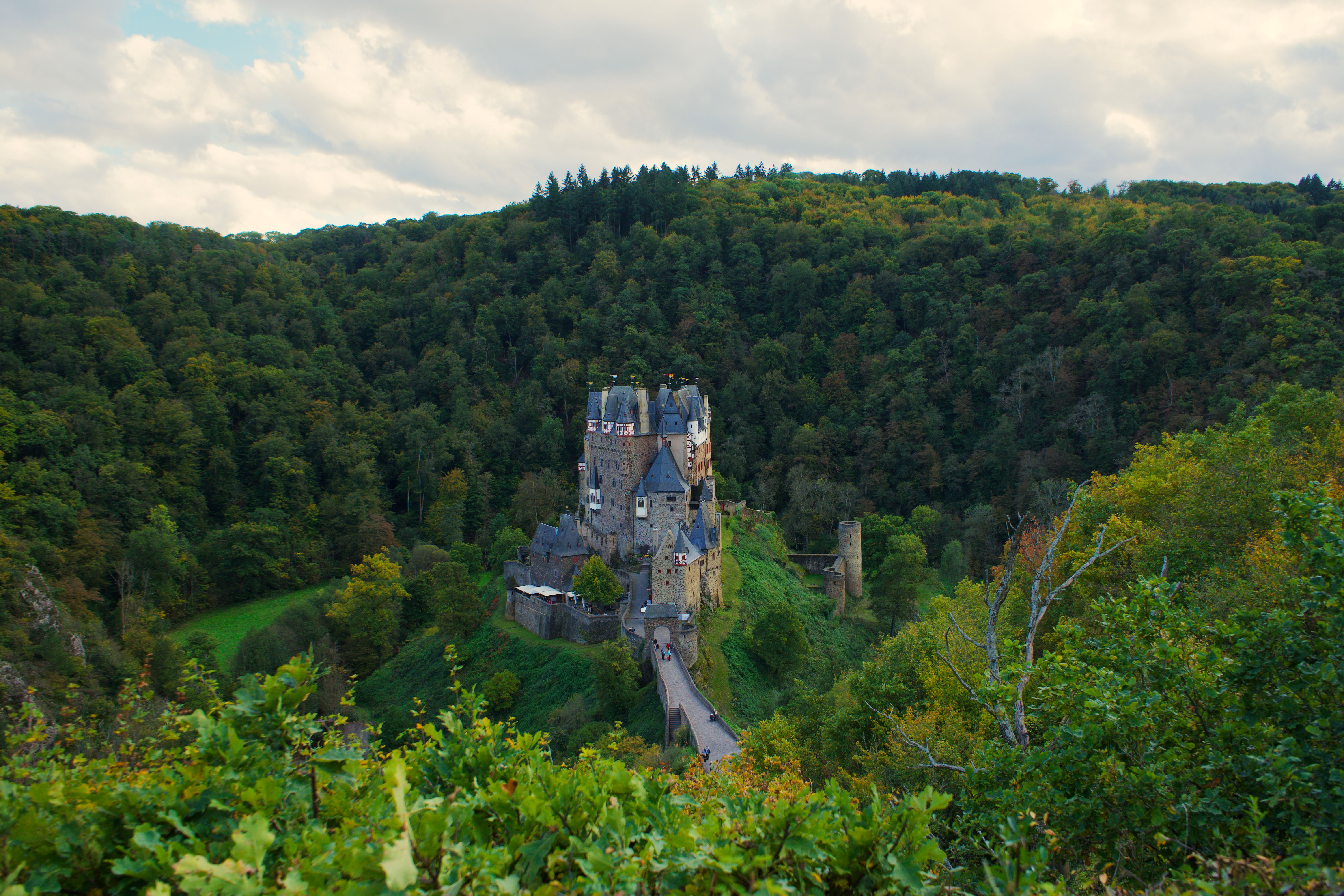 Discover the medieval charm of Eltz Castle surrounded by lush autumn forests in Wierschem, Germany.
