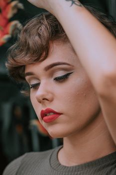 Close-up portrait of an elegant woman with red lipstick and stylish makeup.