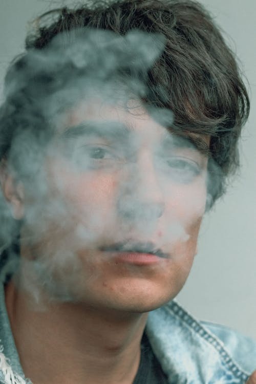 男の顔を覆う煙