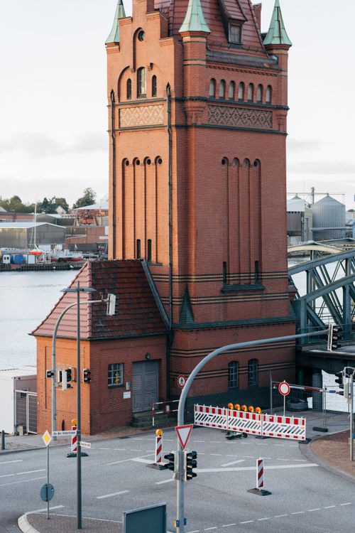 Free Charming red brick tower near the bridge in Lübeck, showcasing architectural elegance and urban scenery. Stock Photo