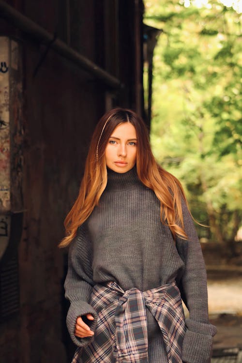 Young Woman in a Sweater Standing Outside 