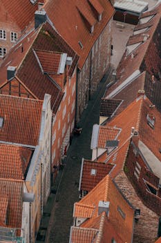 Drone shot capturing the narrow cobblestone streets and historic rooftops of Lübeck's old town. by Gül Işık