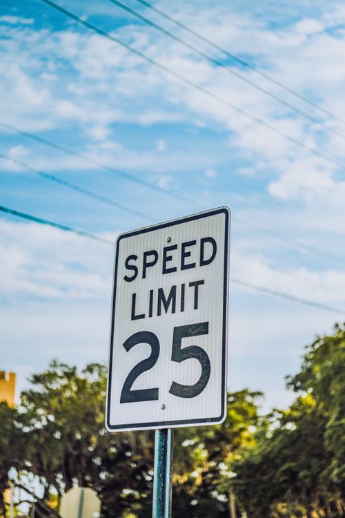 Free A speed limit 25 road sign stands prominently against a clear blue sky. Stock Photo