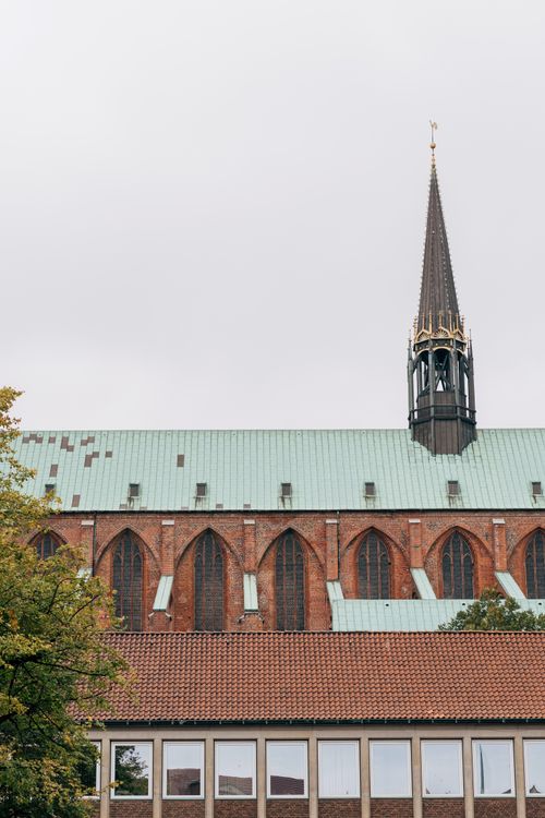 Free A classic Gothic cathedral in Lübeck, Germany with a striking tower, captured on a cloudy day. Stock Photo