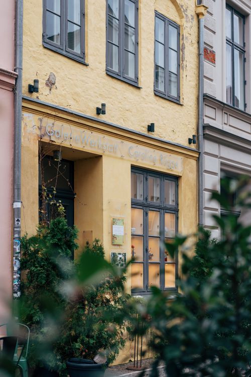Free A historic yellow tenement building with lush greenery in Lübeck, Germany. Stock Photo