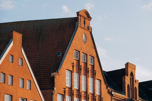 Free Charming medieval brick buildings in Lübeck, Germany under a clear blue sky. Stock Photo