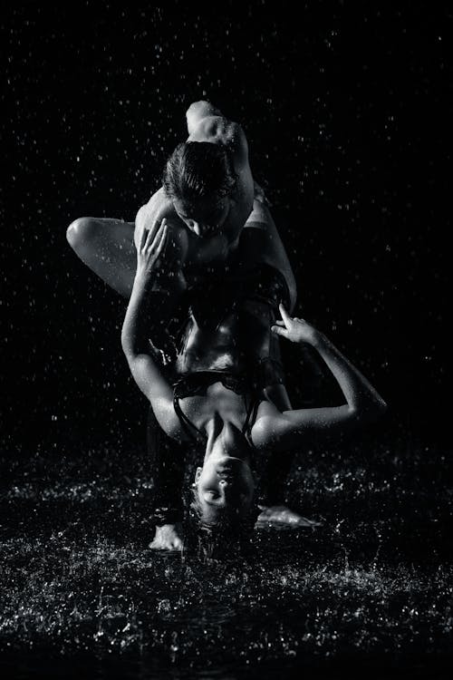 Black and White Photo of Man and Woman Dancing in the Rain