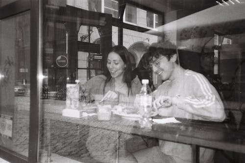 Smiling Couple Sitting behind Restaurant Window