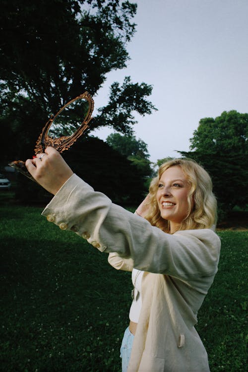 Free Smiling Blonde with Mirror in Park Stock Photo