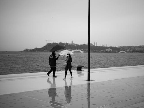 Pedestrians with Umbrellas Walking on Promenade in Turkey