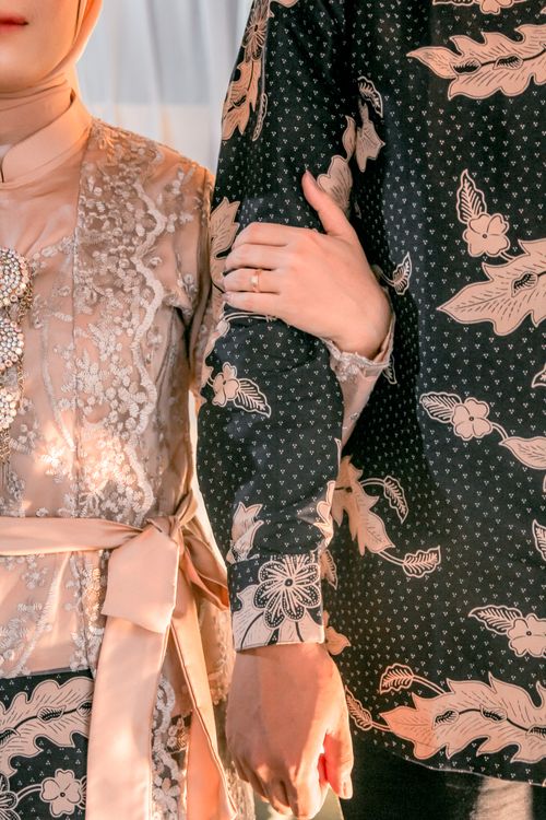 Free Close-up of a couple in ornate traditional clothing holding hands elegantly. Stock Photo