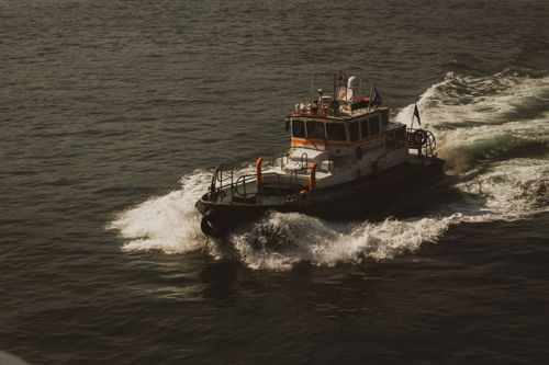 Free A powerful tugboat making way through ocean waters, showcasing maritime strength and agility. Stock Photo