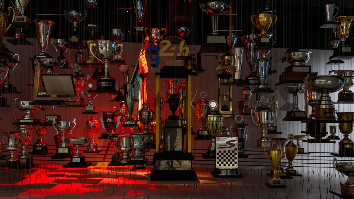 Perete cu zeci de trofee de motorsport pe rafturi